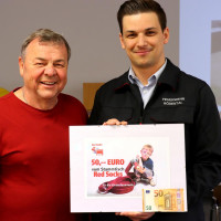 Der Organisator des Stammtisches "Red Socks", Richard Holm" überreicht eine Geldspende an den Kommandanten der Freiwilligen Feuerwehr, Patrick Lesch